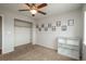 Neutral bedroom with tan carpet and closet, featuring decorative automotive-themed art adorning the walls at 7506 Chipmunk Pl, Littleton, CO 80125