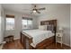 Cozy bedroom with hardwood floors, a ceiling fan, and multiple windows at 7506 Chipmunk Pl, Littleton, CO 80125