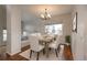 Bright dining room features wood floors, modern chandelier, and large window at 7506 Chipmunk Pl, Littleton, CO 80125