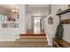 Inviting entryway with hardwood floors, carpeted stairs, coat rack and bright light fixture at 7506 Chipmunk Pl, Littleton, CO 80125