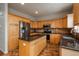 Bright kitchen featuring stainless steel appliances, granite countertops, and a functional center island at 7506 Chipmunk Pl, Littleton, CO 80125