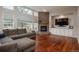 Comfortable living room featuring a fireplace, hardwood floors, and large windows providing natural light at 7506 Chipmunk Pl, Littleton, CO 80125