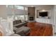 Cozy living room featuring a fireplace, hardwood floors, and large windows providing natural light at 7506 Chipmunk Pl, Littleton, CO 80125