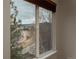 Window view featuring white fencing, an adjacent house, and distant, rolling hills under a cloudy sky at 7506 Chipmunk Pl, Littleton, CO 80125