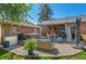Expansive backyard with brick house, hot tub, outdoor seating, dining area, and lush green lawn at 6925 W 27Th Ave, Wheat Ridge, CO 80033