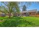 Expansive backyard showcasing a lush green lawn, mature trees, and outdoor living spaces at 6925 W 27Th Ave, Wheat Ridge, CO 80033