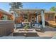 Relaxing backyard patio with a hot tub, seating, a fire pit, outdoor dining area, and well-manicured landscaping at 6925 W 27Th Ave, Wheat Ridge, CO 80033