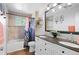 Stylish bathroom featuring double sinks, granite counters, modern fixtures, and a shower with tub at 6925 W 27Th Ave, Wheat Ridge, CO 80033
