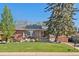 Charming brick home with a well-manicured lawn and inviting outdoor seating area on the patio at 6925 W 27Th Ave, Wheat Ridge, CO 80033