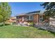 Charming brick home with a well-manicured lawn and inviting outdoor seating area on the patio at 6925 W 27Th Ave, Wheat Ridge, CO 80033