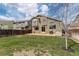 A wide backyard with green grass, a shed, grill and a back exterior view of the home at 5368 Creek Way, Parker, CO 80134