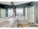 Bright bathroom features dual sinks, bathtub, and glass-enclosed shower with gold trim at 5368 Creek Way, Parker, CO 80134