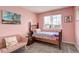 Pretty pink bedroom with matching chair, wood frame bed, and a view of the neighborhood at 5368 Creek Way, Parker, CO 80134