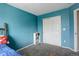 bedroom featuring a white sliding-door closet and blue accent wall at 5368 Creek Way, Parker, CO 80134