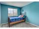Comfortable bedroom with blue accent wall and natural wood frame bed and view at 5368 Creek Way, Parker, CO 80134