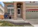 Inviting front porch with comfortable seating, brick accents, and a two-car garage at 5368 Creek Way, Parker, CO 80134