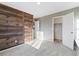 Bedroom features a rustic wood accent wall, light carpet, and neutral paint at 26229 E Maple Dr, Aurora, CO 80018