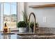 Close-up of a kitchen sink with a modern faucet, granite countertops, and window view at 26229 E Maple Dr, Aurora, CO 80018