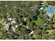 Aerial view of a luxurious estate with a manicured lawn, tennis court, and lush tree coverage at 222 Greystone Rd, Evergreen, CO 80439