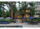 Backyard of a stone house showing an in-ground pool and patio furniture nestled in the trees at 222 Greystone Rd, Evergreen, CO 80439