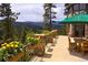 A spacious balcony with stone pillars, flowers and beautiful views of the mountains at 222 Greystone Rd, Evergreen, CO 80439