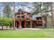 Stunning timber frame home with stone accents and a beautifully landscaped lawn surrounded by mature trees at 222 Greystone Rd, Evergreen, CO 80439