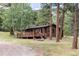 Inviting log cabin with a wooden deck and surrounded by a serene forest at 222 Greystone Rd, Evergreen, CO 80439