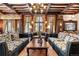 This formal living room features coffered wood ceilings, stone accents, and abundant natural light at 222 Greystone Rd, Evergreen, CO 80439