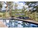 A stunning pool area with elegant lounge chairs surrounded by trees and landscaping at 222 Greystone Rd, Evergreen, CO 80439