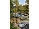 A beautiful waterfall feature flowing into a pool surrounded by lush greenery and rock landscaping at 222 Greystone Rd, Evergreen, CO 80439