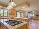 Open-concept kitchen featuring island cooktop, marble countertops, and seamless flow into living area at 20380 Silver Horn Ln, Monument, CO 80132