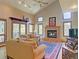 Cozy living room featuring a brick fireplace, plush sofas, and large windows with wooded views at 20380 Silver Horn Ln, Monument, CO 80132