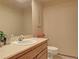 Clean powder room featuring a white sink, toilet, and wood vanity at 20380 Silver Horn Ln, Monument, CO 80132