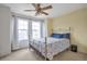 Serene bedroom with soft yellow walls, carpet, a ceiling fan, and windows providing natural light at 9369 Longs Peak Dr, Henderson, CO 80640