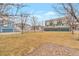 Well-maintained townhomes with manicured lawns, garages, and mature trees, creating an inviting streetscape at 9369 Longs Peak Dr, Henderson, CO 80640