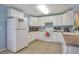 Bright kitchen featuring clean white cabinets, a tiled floor, and efficient appliances at 9369 Longs Peak Dr, Henderson, CO 80640