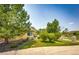 Well-kept backyard with lush green lawn, mature trees, and a stone-lined garden area at 22405 E Plymouth Cir, Aurora, CO 80016