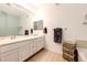 A bright bathroom with double sinks, vanity, and linen storage at 22405 E Plymouth Cir, Aurora, CO 80016