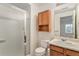 Bathroom featuring white toilet, shower with glass door, and wooden sink vanity at 831 W Kettle Ave, Littleton, CO 80120