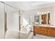 Bathroom featuring double sink vanity with wooden cabinets, shower, tub, and bright natural light at 831 W Kettle Ave, Littleton, CO 80120