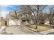 View of the exterior featuring a brick facade, attached garage, driveway, and well-maintained yard at 831 W Kettle Ave, Littleton, CO 80120