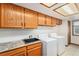 Laundry room with ample cabinet space, utility sink, and window at 831 W Kettle Ave, Littleton, CO 80120