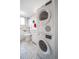 Bright bathroom features stackable washer/dryer, marble tile flooring, and bathtub with marble tile surround at 33 N Corona St # 205, Denver, CO 80218
