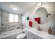 Modern bathroom with marble tile, a bathtub, and a sleek round mirror at 33 N Corona St # 205, Denver, CO 80218