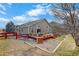 Backyard view featuring a spacious deck perfect for outdoor seating, with a red fence, gravel, and minimal lawn at 2347 Switch Grass Way, Castle Rock, CO 80109