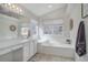 A serene bathroom with a soaking tub, white cabinetry, and natural light from two well-placed windows at 2347 Switch Grass Way, Castle Rock, CO 80109