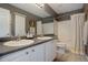 Bathroom with double sinks, white cabinets, and a shower-tub combination featuring a neutral-colored shower curtain at 2347 Switch Grass Way, Castle Rock, CO 80109