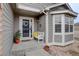 Inviting front porch with a white bench, potted plants, and a charming wreath on the front door at 2347 Switch Grass Way, Castle Rock, CO 80109