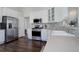 Well-lit kitchen featuring white cabinets, stainless steel appliances, and tile backsplash at 2347 Switch Grass Way, Castle Rock, CO 80109