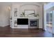 Bright living room with a fireplace, built-in shelving, and dark hardwood floors at 2347 Switch Grass Way, Castle Rock, CO 80109